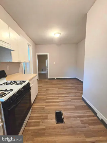a kitchen with stainless steel appliances wooden floor and a refrigerator