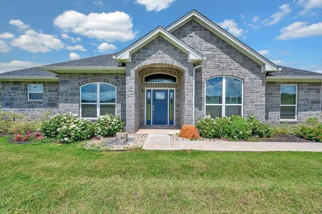 a front view of a house with a garden and plants
