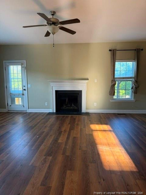 1284 L L Cooper Road Cameron, NC 28326 - Photo 3 of 24 an empty room with wooden floor a fireplace and windows