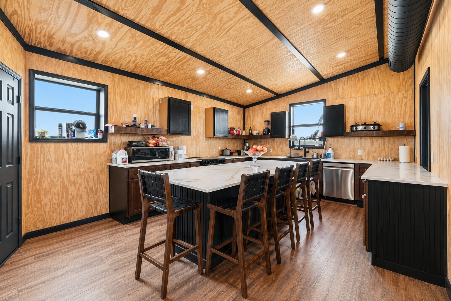 1701 County Road 466 Elgin, TX 78621 - Photo 4 of 24 A contemporary kitchen features a spacious island with ample seating, integrated appliances, and recessed lighting.