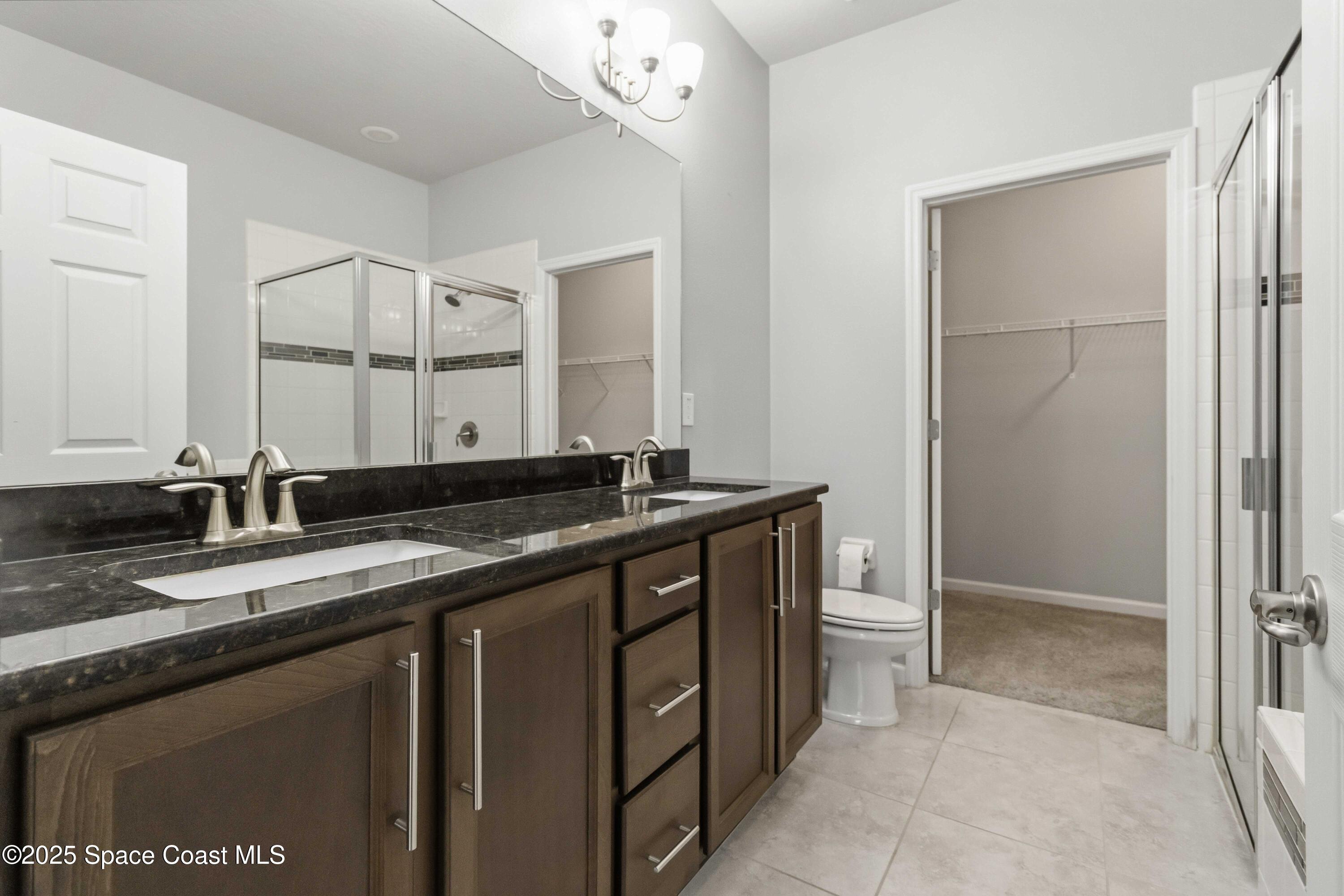 988 Corbin Circle Southwest Palm Bay, FL 32908 - Photo 12 of 26 a bathroom with a granite countertop sink and a mirror