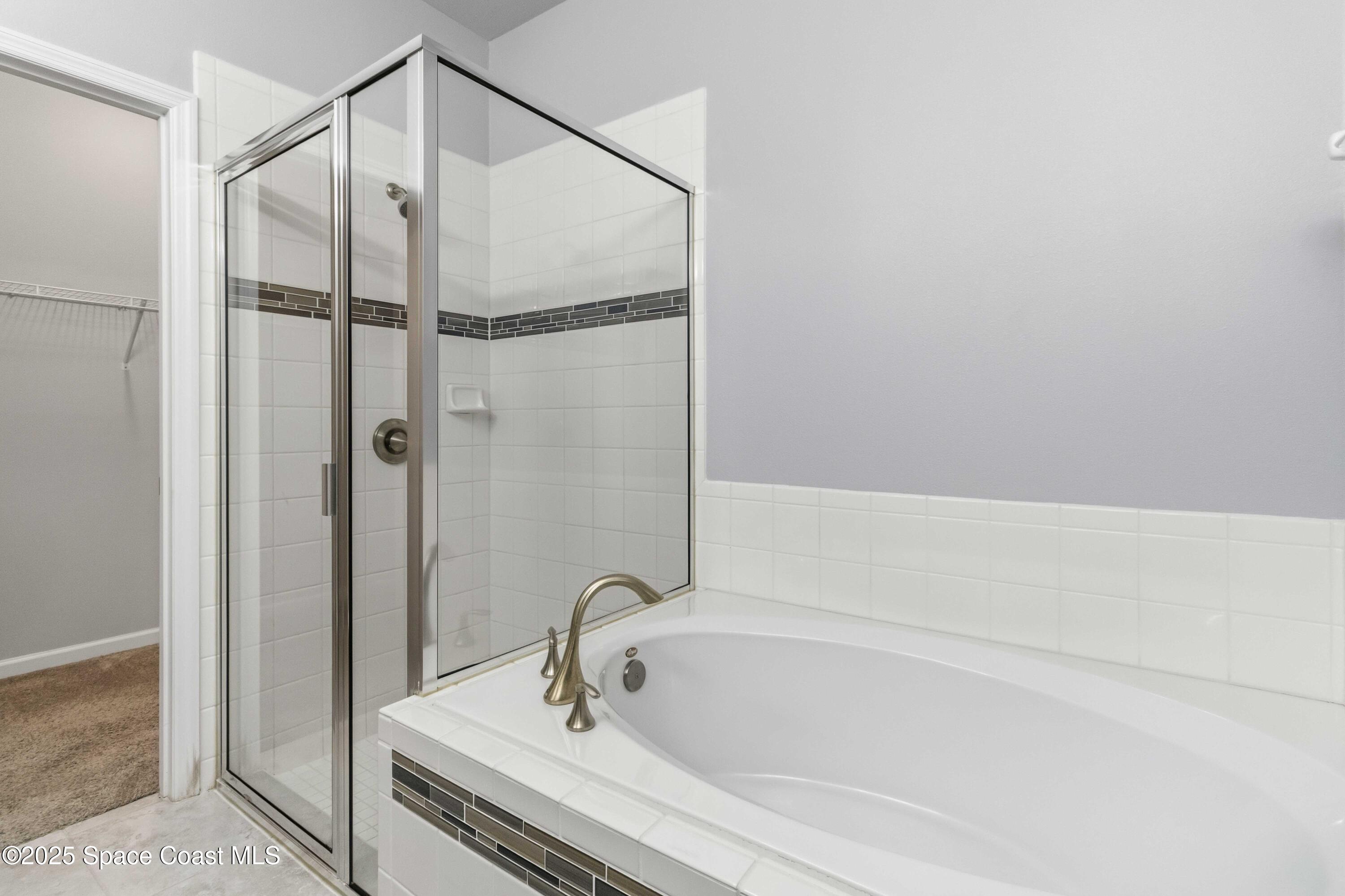 988 Corbin Circle Southwest Palm Bay, FL 32908 - Photo 14 of 26 a bathroom with a tub and a shower