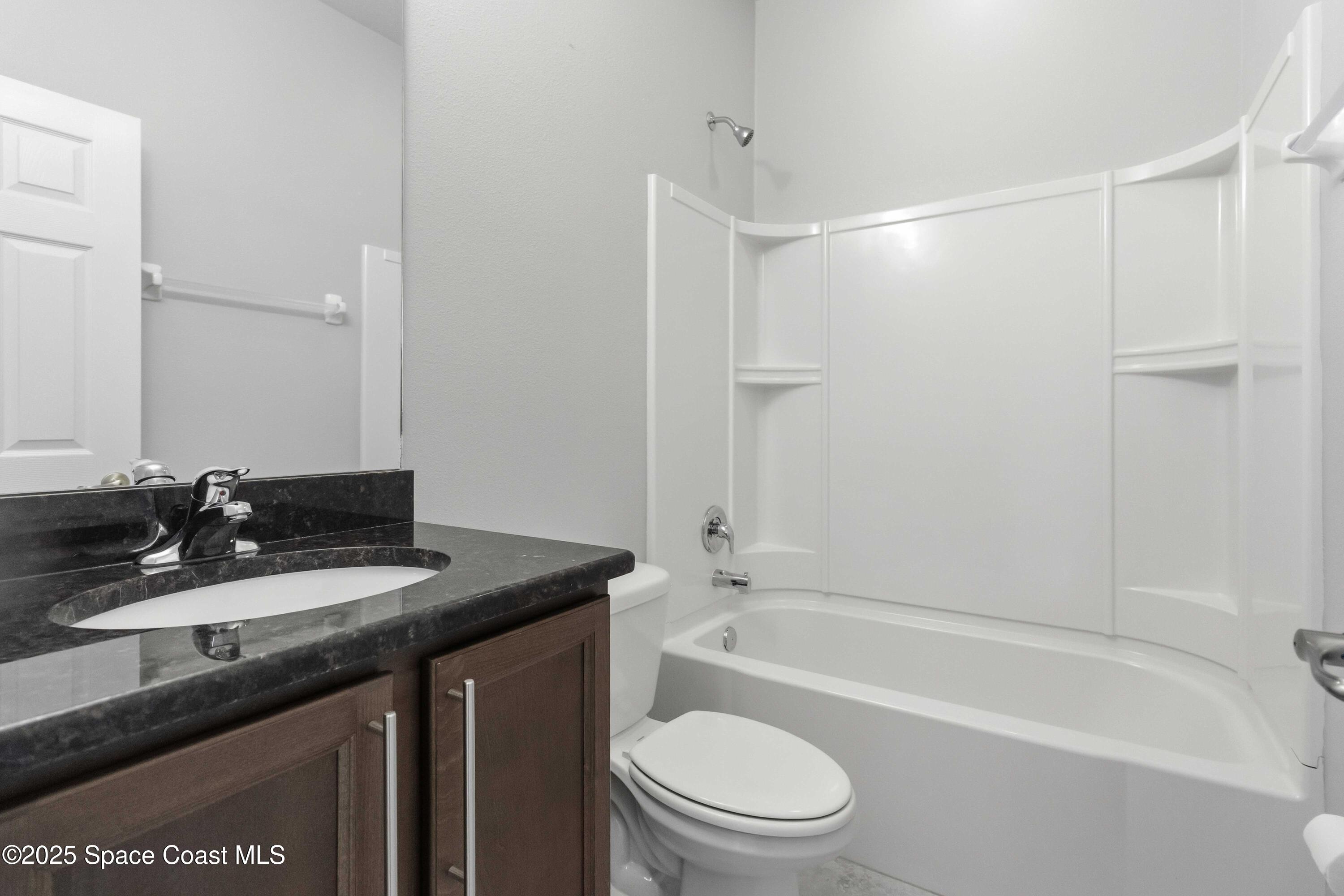 988 Corbin Circle Southwest Palm Bay, FL 32908 - Photo 19 of 26 a bathroom with a granite countertop sink toilet and shower