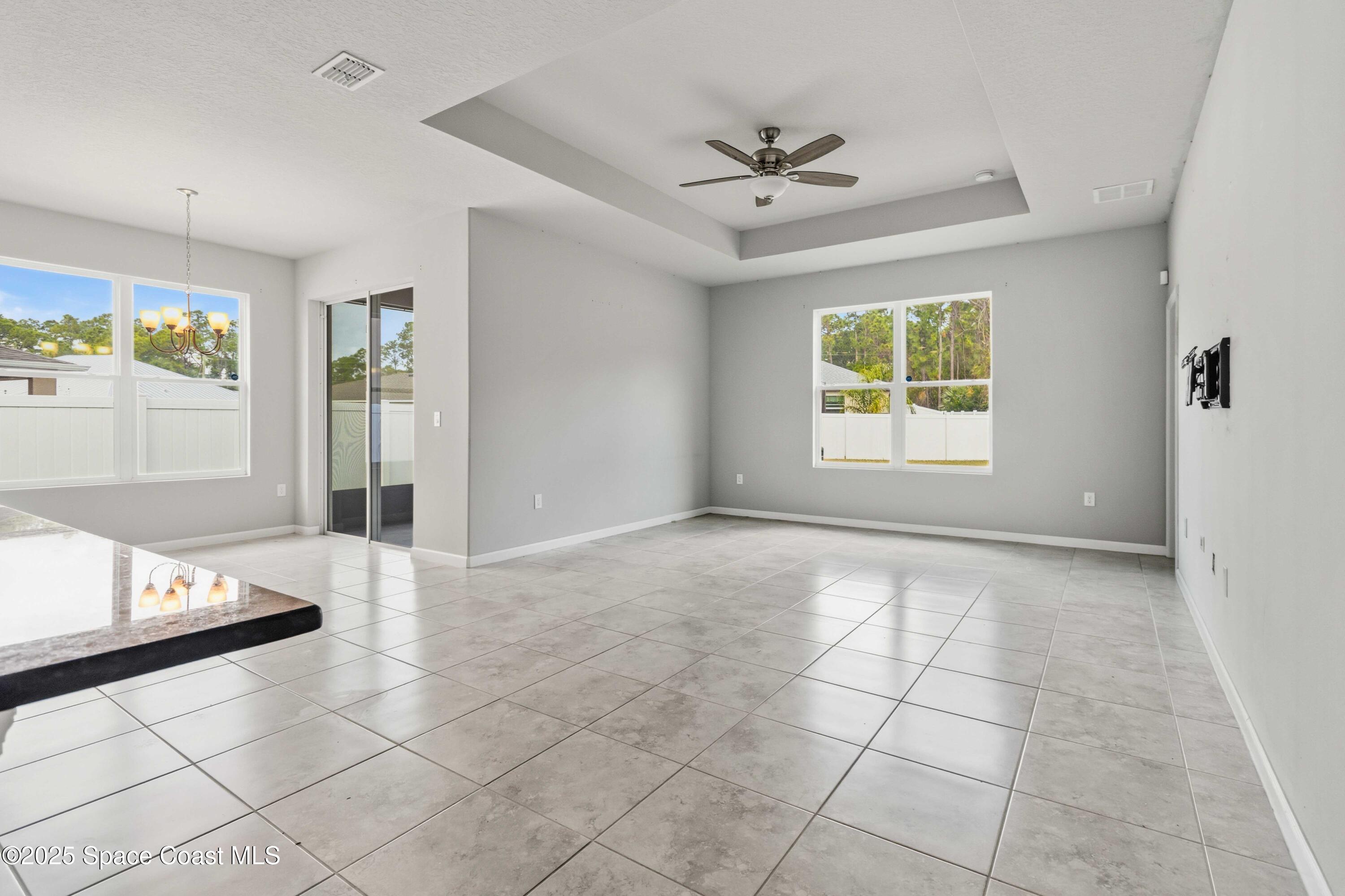 988 Corbin Circle Southwest Palm Bay, FL 32908 - Photo 9 of 26 a view of an empty room with window and chandelier fan