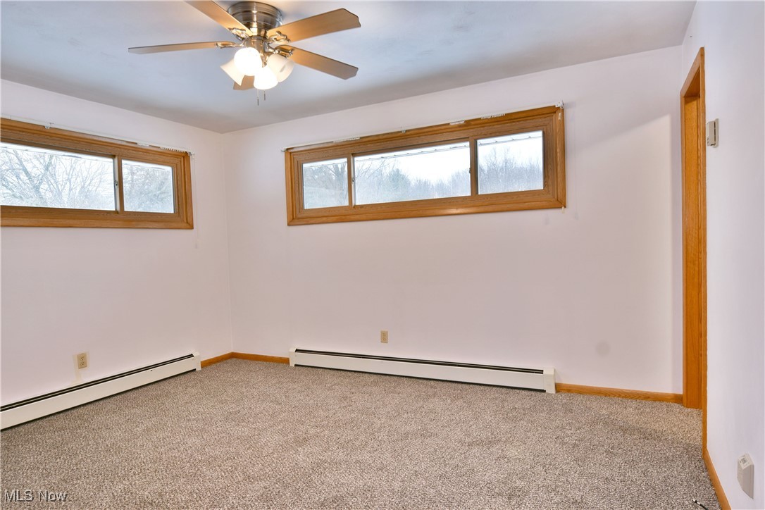 7155 Drake State Line Road Burghill, OH 44404 - Photo 25 of 50 Spare room featuring carpet flooring, a baseboard radiator, and a ceiling fan
