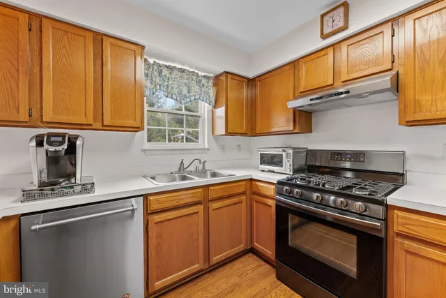 a kitchen with stainless steel appliances granite countertop a sink stove and cabinets