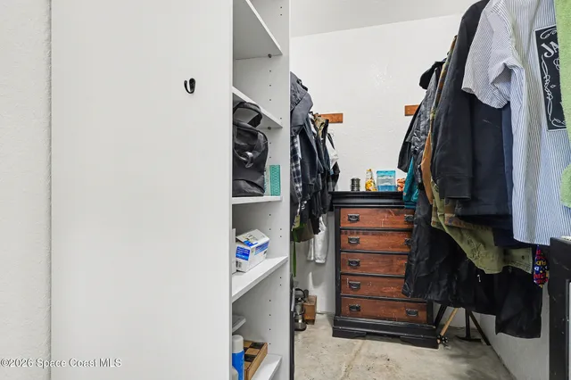 a view of walk in closet with clothes and shoes