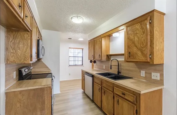 a kitchen with stainless steel appliances a sink a stove and a refrigerator