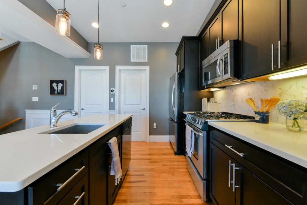 5 Grimes Street, Unit 3 Boston, MA 02127 - Photo 10 of 16 a kitchen with stainless steel appliances granite countertop a sink a stove and a refrigerator