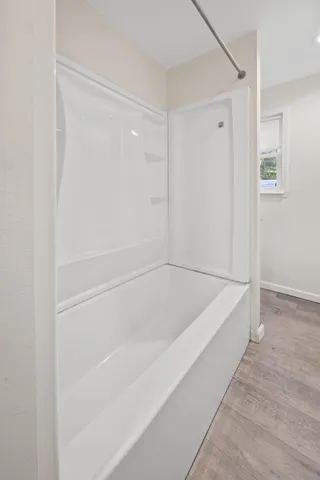 an empty room with a window and a ceiling fan