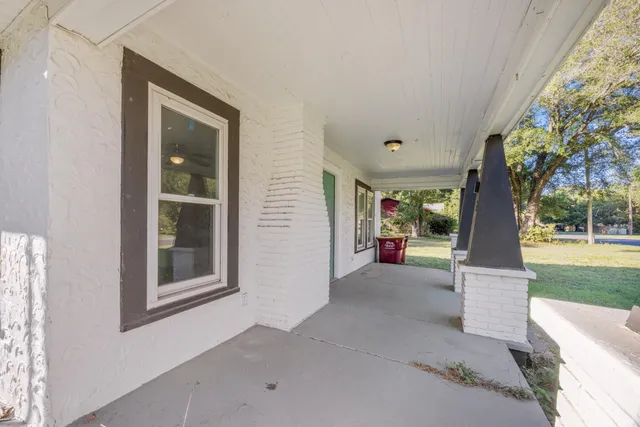 a view of a house with a porch and garden