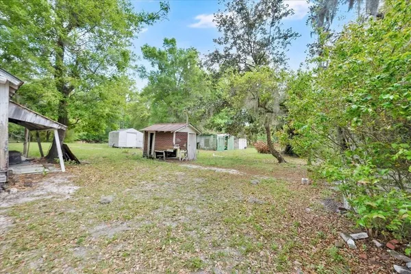a view of a house with backyard and a tree