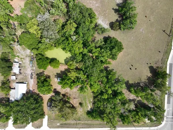 an aerial view of a residential houses with yard