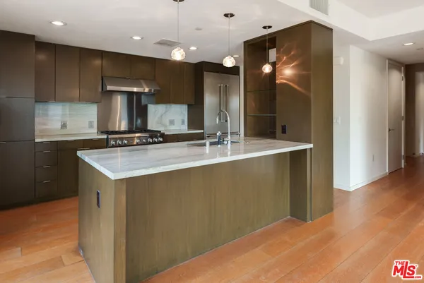 a kitchen with kitchen island a sink stainless steel appliances and cabinets