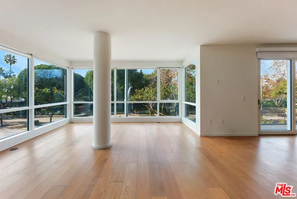 a view of a garden with wooden floor and windows