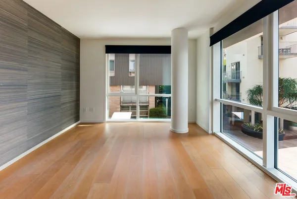 a view of a big room with wooden floor and windows