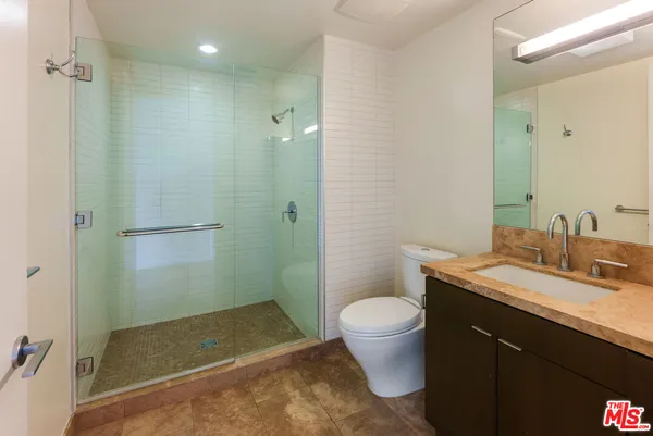 a bathroom with a granite countertop sink toilet and shower