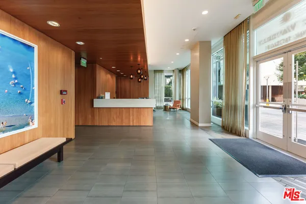 a view of a hallway with wooden floor and a bathroom