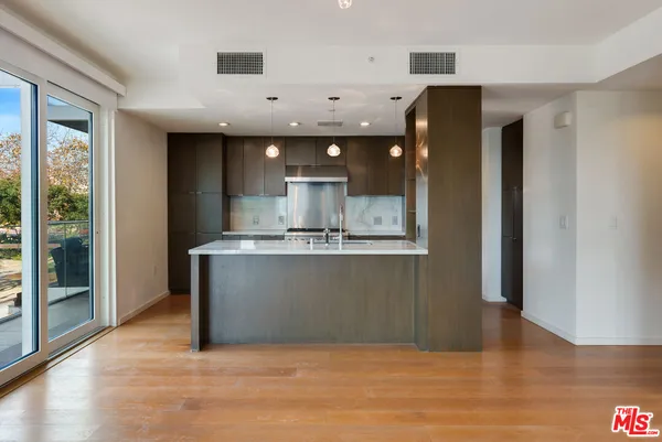 a view of kitchen with stainless steel appliances granite countertop cabinets and wooden floor
