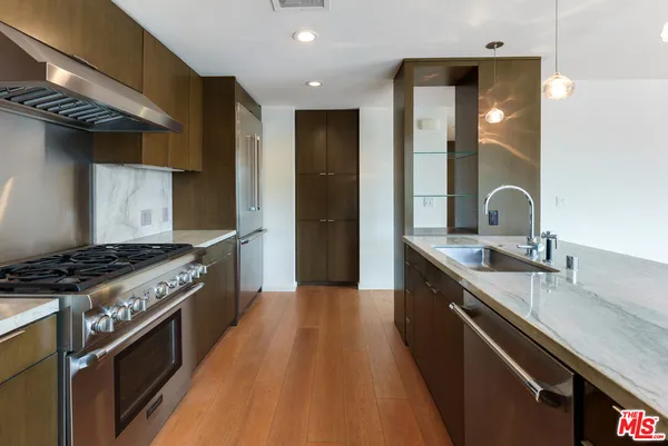 a kitchen with granite countertop a sink stove and cabinets