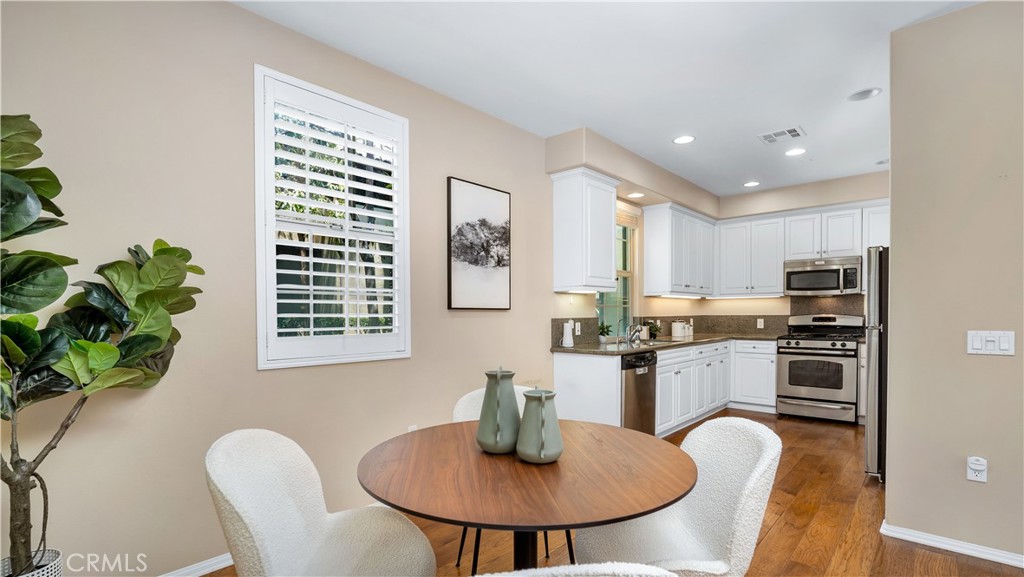 66 Full Moon Irvine, CA 92618 - Photo 18 of 32 a kitchen with stainless steel appliances granite countertop a stove a kitchen island a dining table and chairs