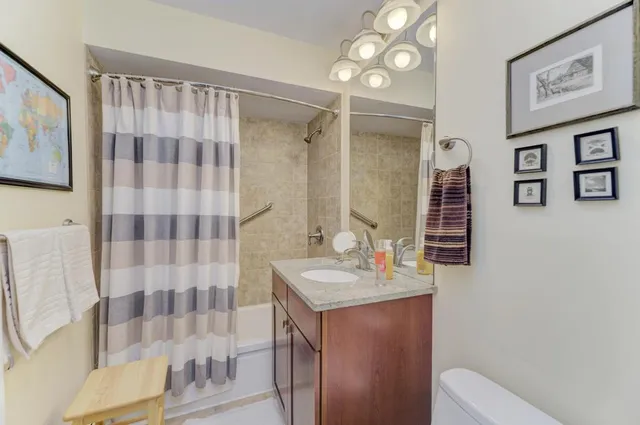 a bathroom with a sink toilet double vanity and shower