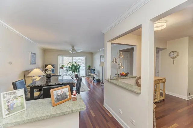 a living room with furniture a chandelier and wooden floor