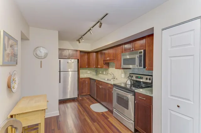 a kitchen with a refrigerator and countertop sink