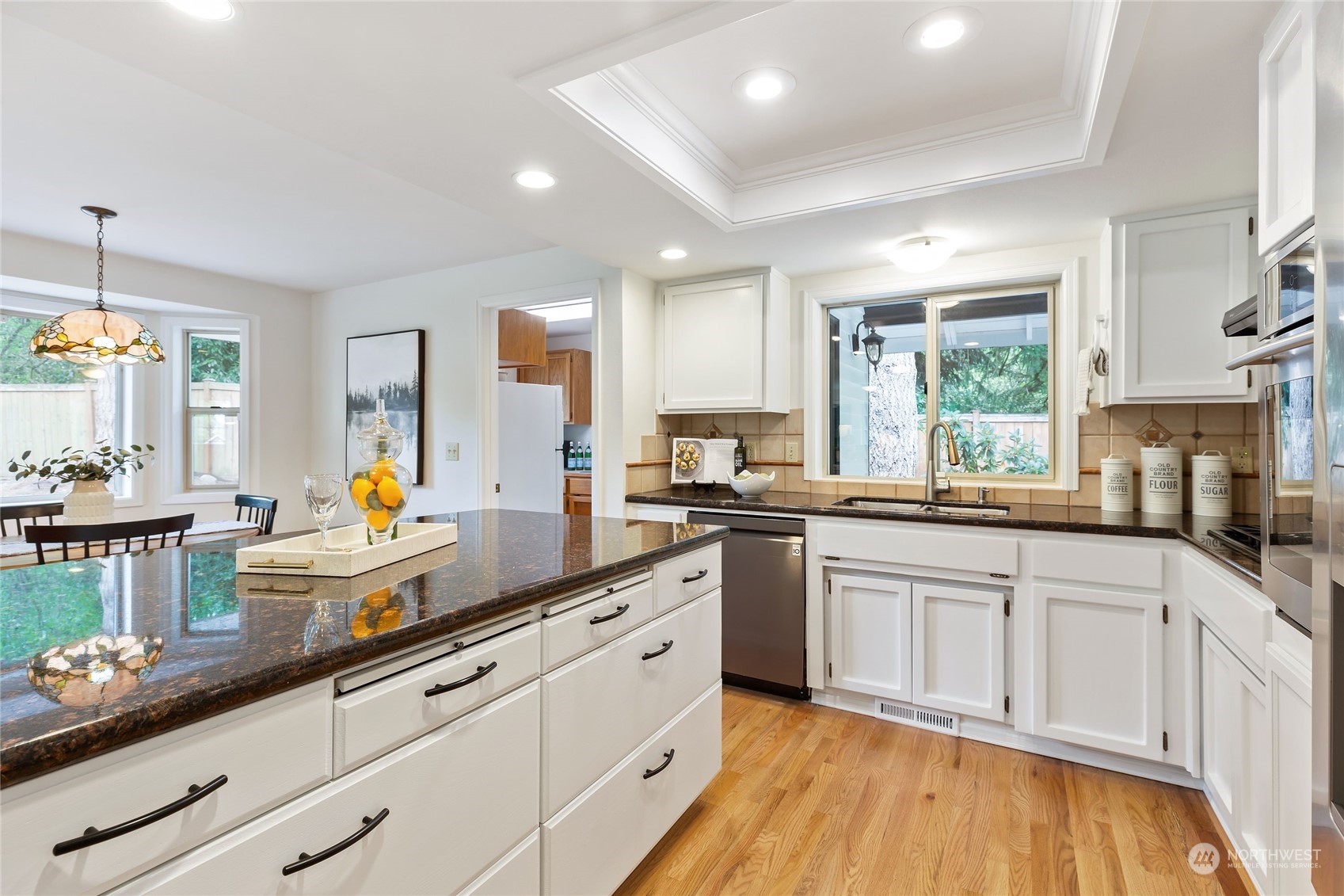 21020 49th Avenue Southeast Bothell, WA 98021 - Photo 13 of 39 a kitchen with white cabinets and wooden floors