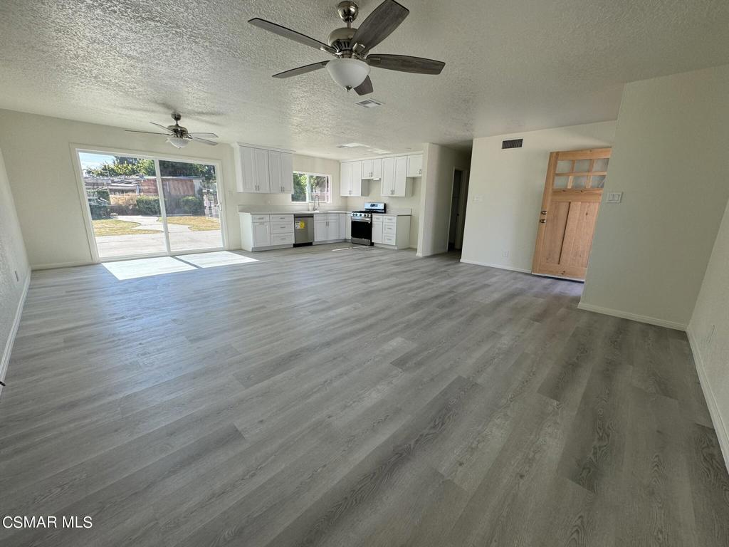 1769 Sitka Avenue Simi Valley, CA 93063 - Photo 2 of 11 an empty room with wooden floor ceiling fan and windows