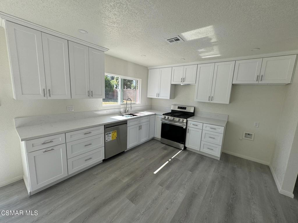 1769 Sitka Avenue Simi Valley, CA 93063 - Photo 3 of 11 a kitchen with granite countertop white cabinets and white stainless steel appliances