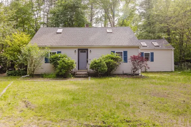 front view of house with a yard and potted plants