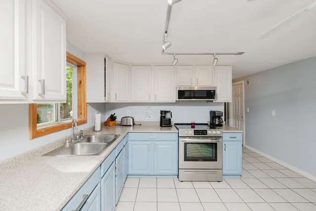 a kitchen with stainless steel appliances a stove sink microwave and cabinets