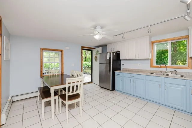 a dining room with stainless steel appliances a table and chairs