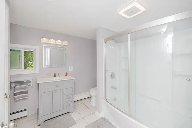 a bathroom with a double vanity sink toilet mirror and bathtub