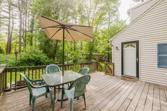 a view of deck with table and chairs under an umbrella