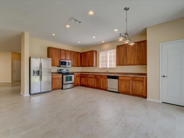 a open kitchen with stainless steel appliances granite countertop a stove top oven a sink and a refrigerator