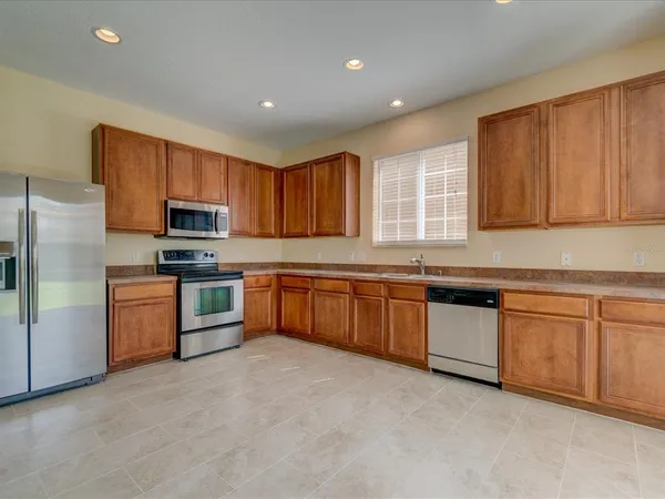 a kitchen with granite countertop a sink stainless steel appliances and cabinets