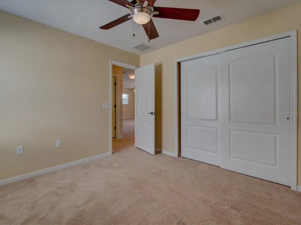 an empty room with chandelier fan
