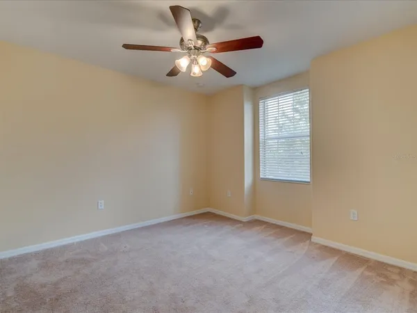an empty room with windows and fan