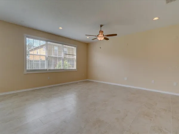 an empty room with windows and fan