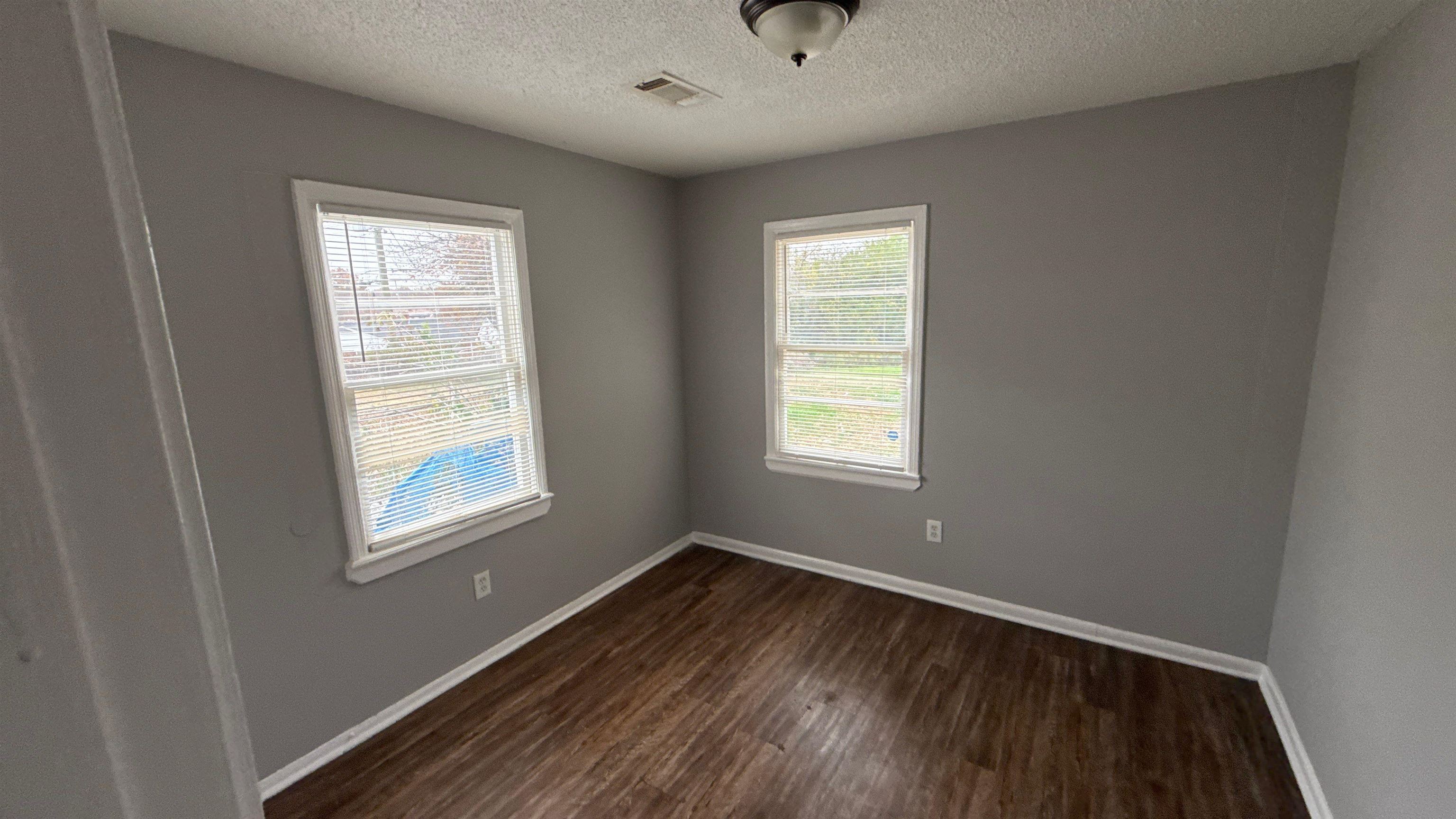 3509 Brantley Road Memphis, TN 38109 - Photo 4 of 9 a view of an empty room with wooden floor and a window