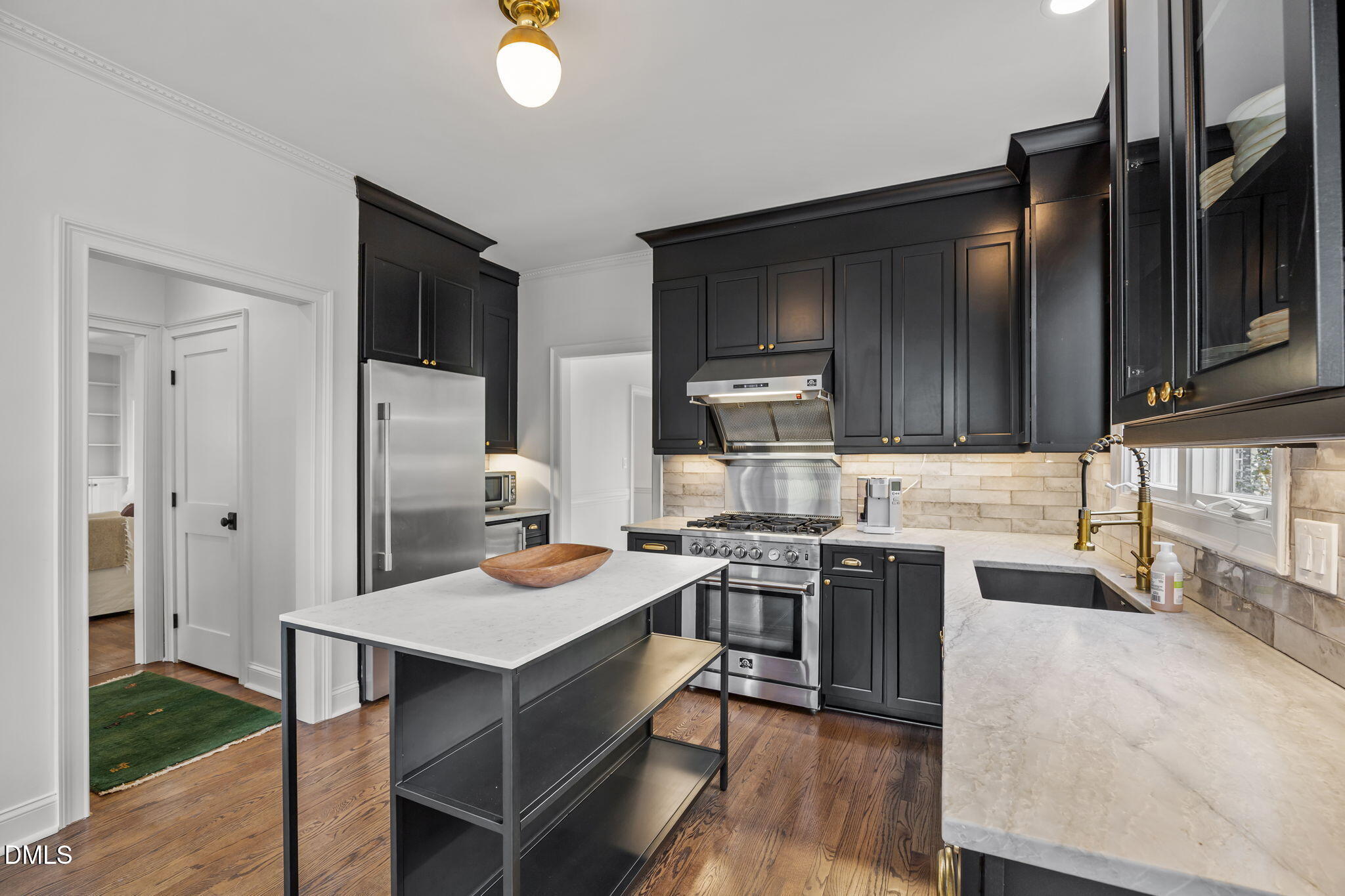 8805 Mourning Dove Road Raleigh, NC 27615 - Photo 17 of 55 a kitchen with stainless steel appliances a stove a sink dishwasher and a refrigerator with wooden floor