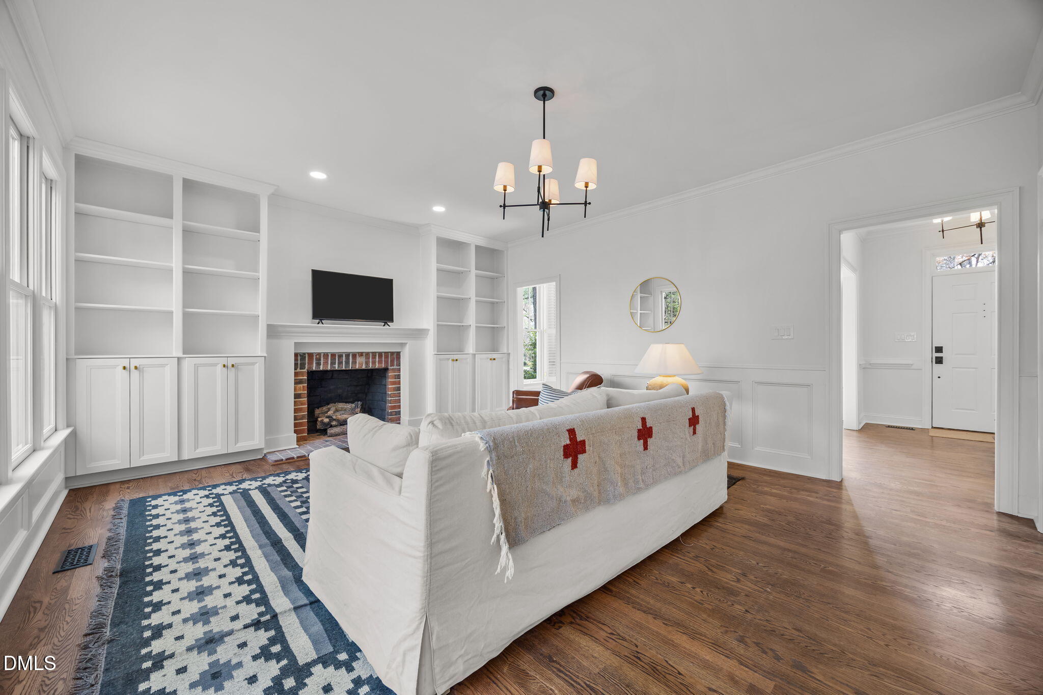 8805 Mourning Dove Road Raleigh, NC 27615 - Photo 8 of 55 a white bed sitting in a living room with a fireplace and a chandelier