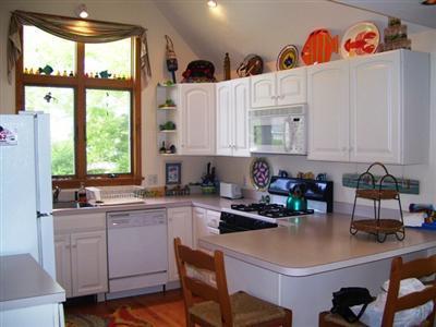 138 Mashnee Road Bourne, MA 02532 - Photo 6 of 15 a kitchen with a sink a stove and white cabinets