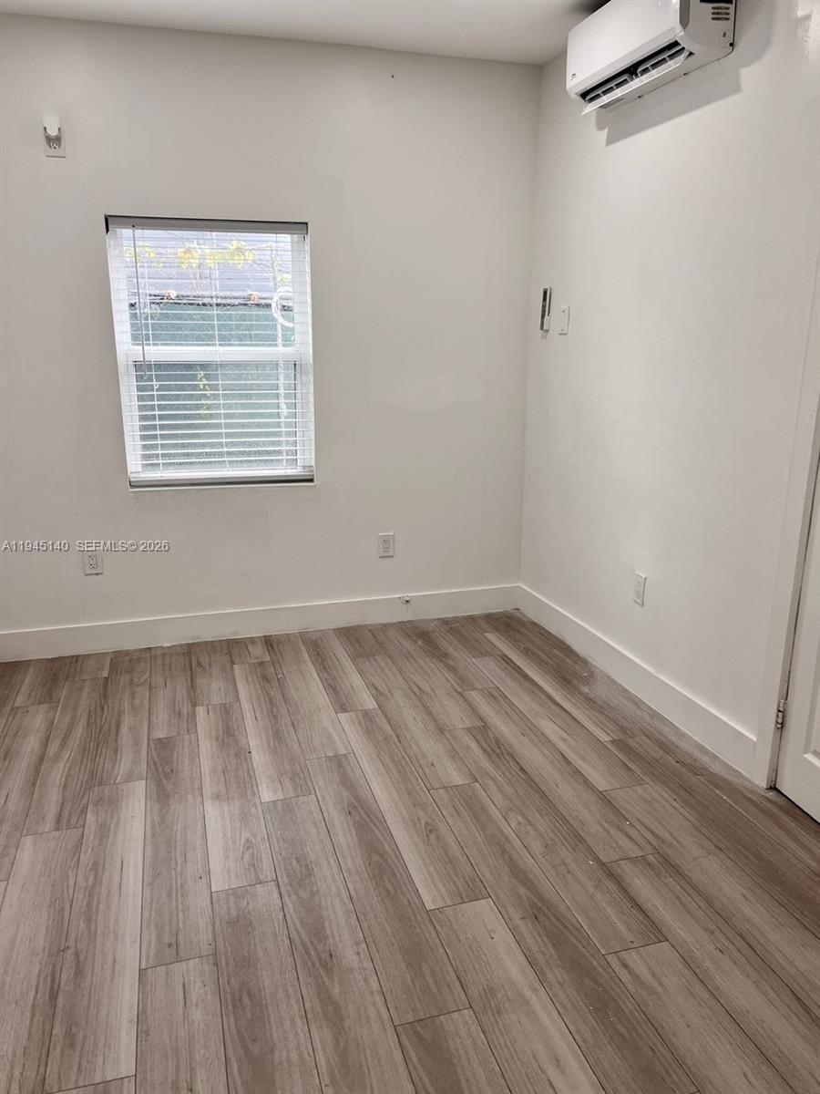 852 Southwest 13th Avenue, Unit 3 Miami, FL 33135 - Photo 8 of 20 a view of a room with wooden floor and a window