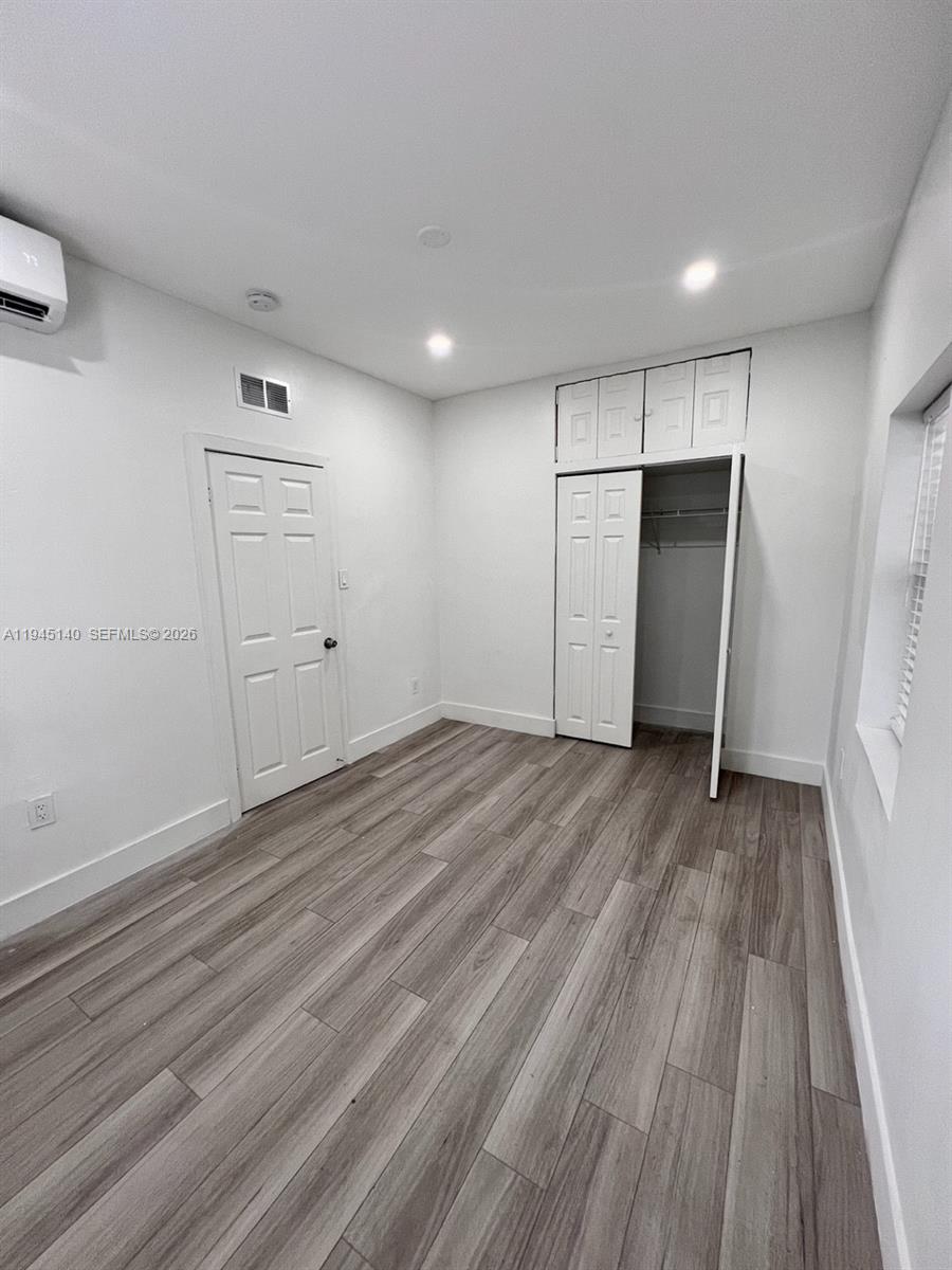 852 Southwest 13th Avenue, Unit 3 Miami, FL 33135 - Photo 10 of 20 a view of empty room with wooden floor and window