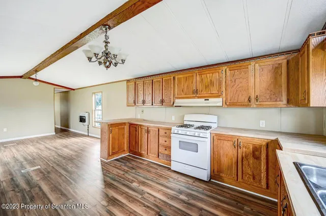 a kitchen with granite countertop wooden floors and stainless steel appliances