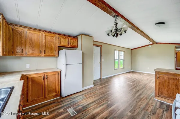 a view of a kitchen with wooden floor and electronic appliances
