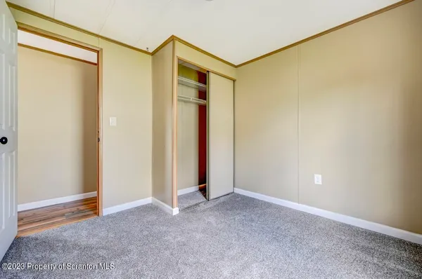 a view of a hallway with wooden floor and furniture